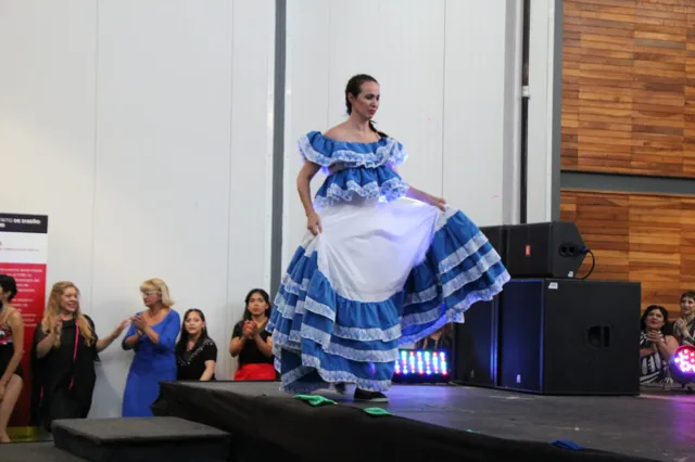 Una participante muestra su vestido azul y blanco sobre la pasarela.